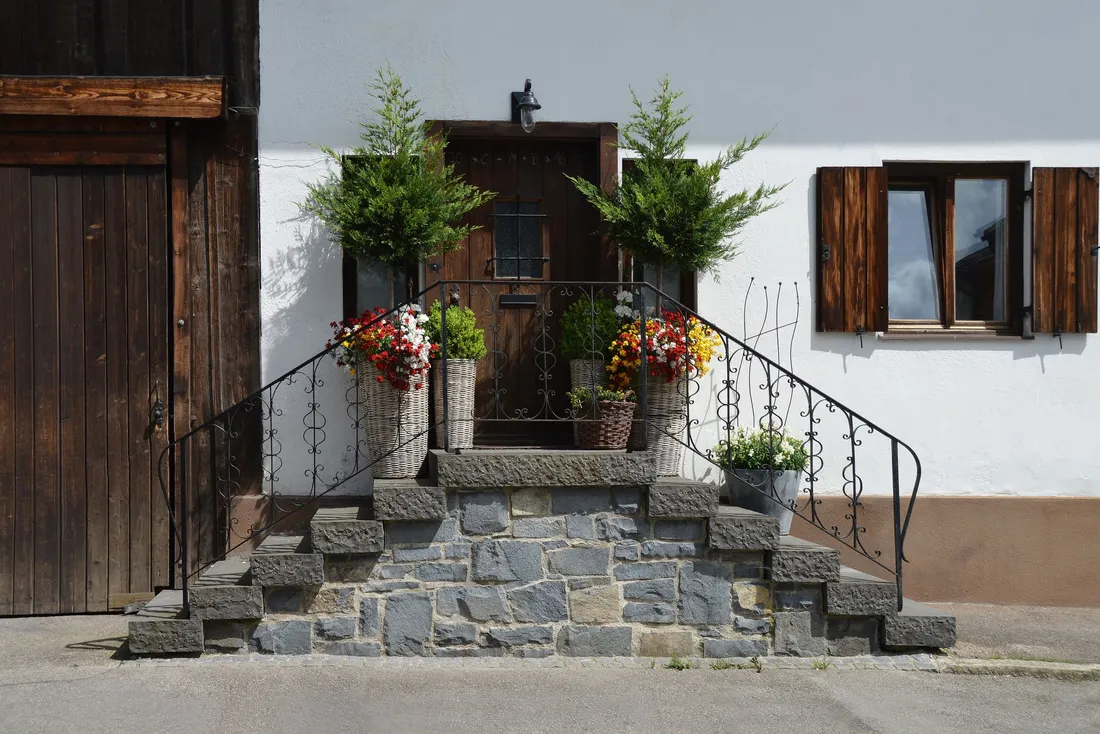 Perron en pierre fleuri devant une maison blanche aux volets en bois (Biscarrosse, Landes)