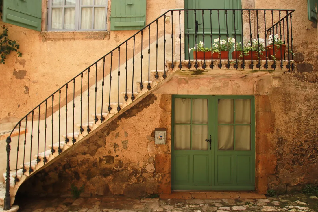 Escalier extérieur à rampe en fer sur une façade ocre à porte verte (Villaines-les-Rochers, Indre-et-Loire)